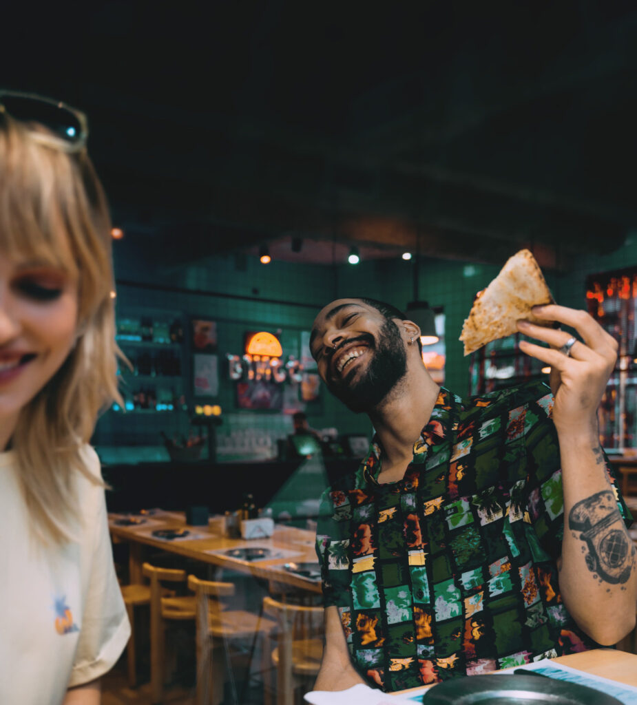 Jeune femme et jeune homme mangeant dans un restaurant.