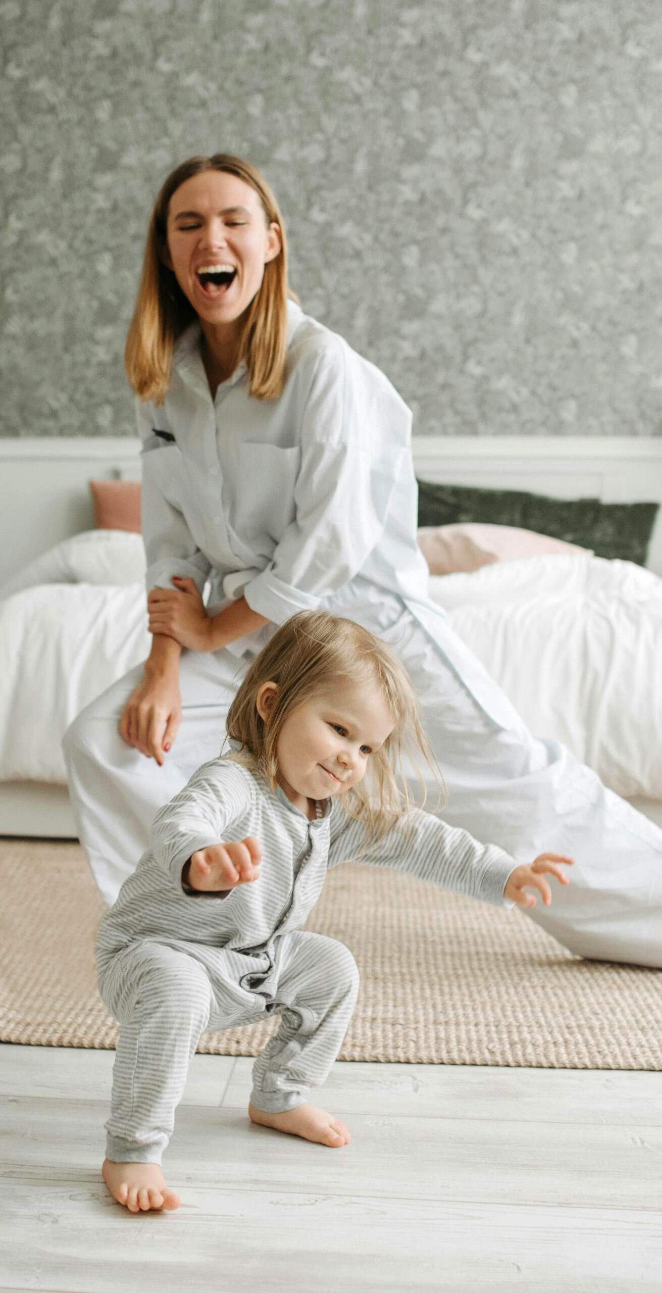 Femme caucasienne faisant du karaté et sourit en voyant son enfant en avant plan.